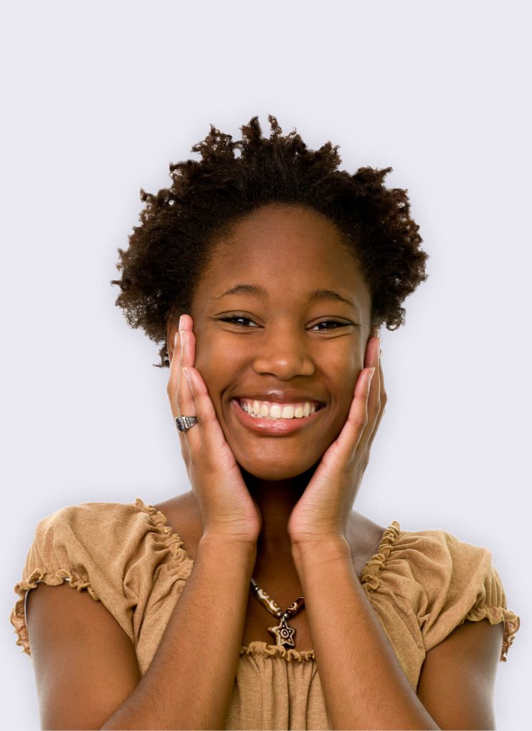 A young woman holding her hands up to her face and smiling.