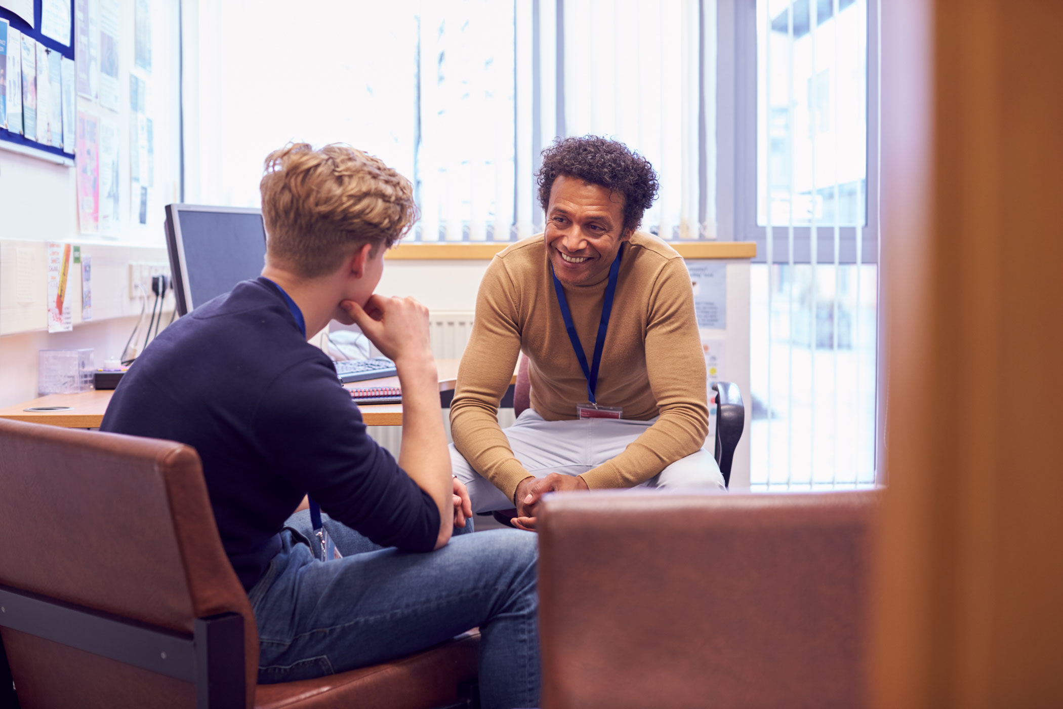 iStock-1218975578-web African american counselor sitting across client, engaging in a way that conveys a patient centered care model