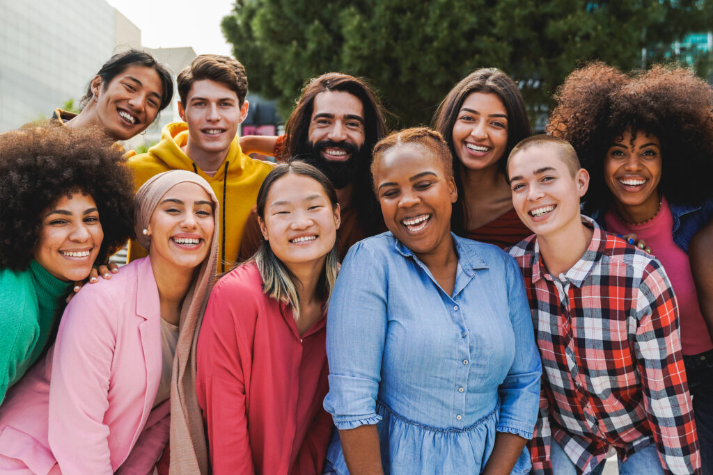 A group of diverse young adults, smiling and posing for a group picture.