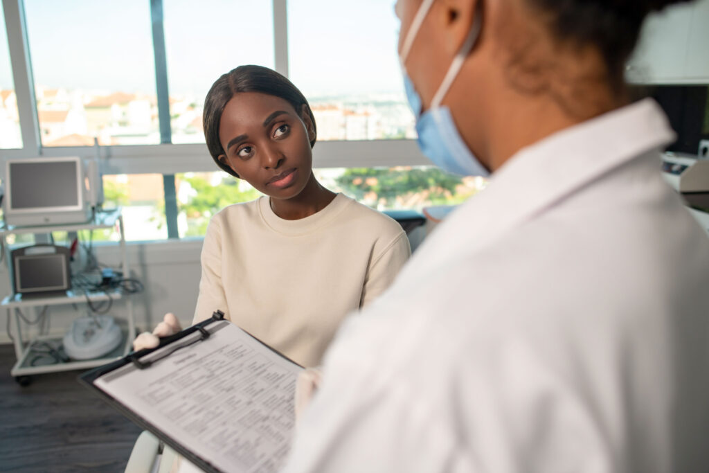 General practitioner asking questions to young female patient