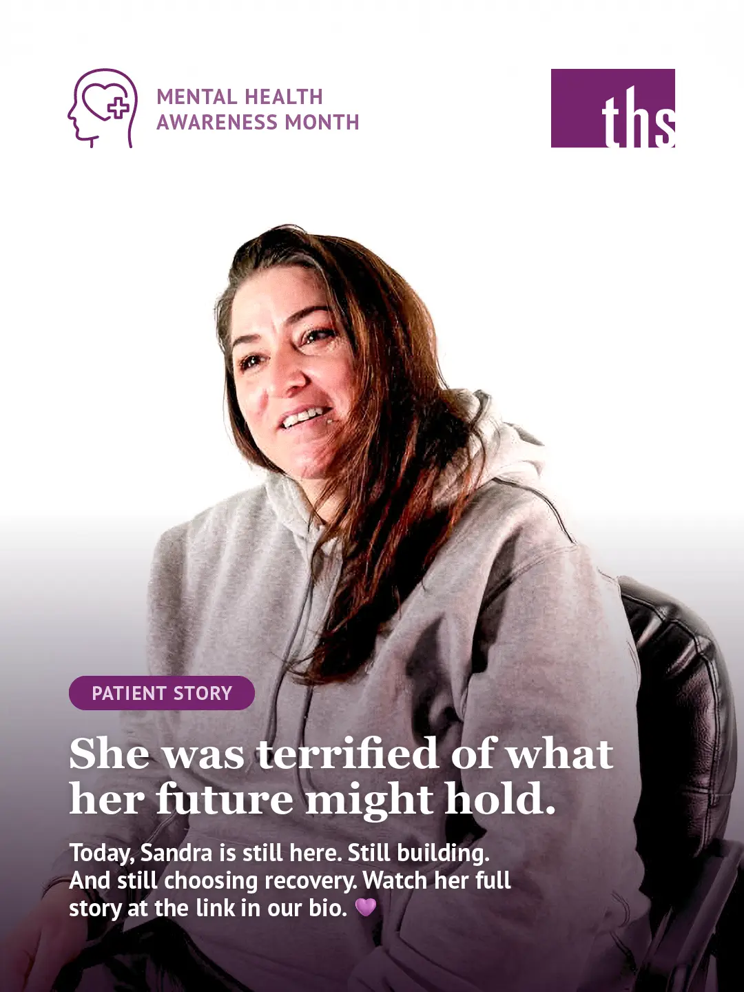 A patient story graphic for Therapeutic Health Services. In the top left, a purple Mental Health Awareness Month icon. The THS logo appears in the top right. A woman with long brown hair sits in a chair, looking upward with a gentle, hopeful expression, wearing a gray hoodie. A purple gradient fades up from the bottom of the image. A purple "Patient Story" badge sits above bold white text reading: "She was terrified of what her future might hold." Below in smaller white text: "Today, Sandra is still here. Still building. And still choosing recovery. Watch her full story at the link in our bio." followed by a purple heart emoji.