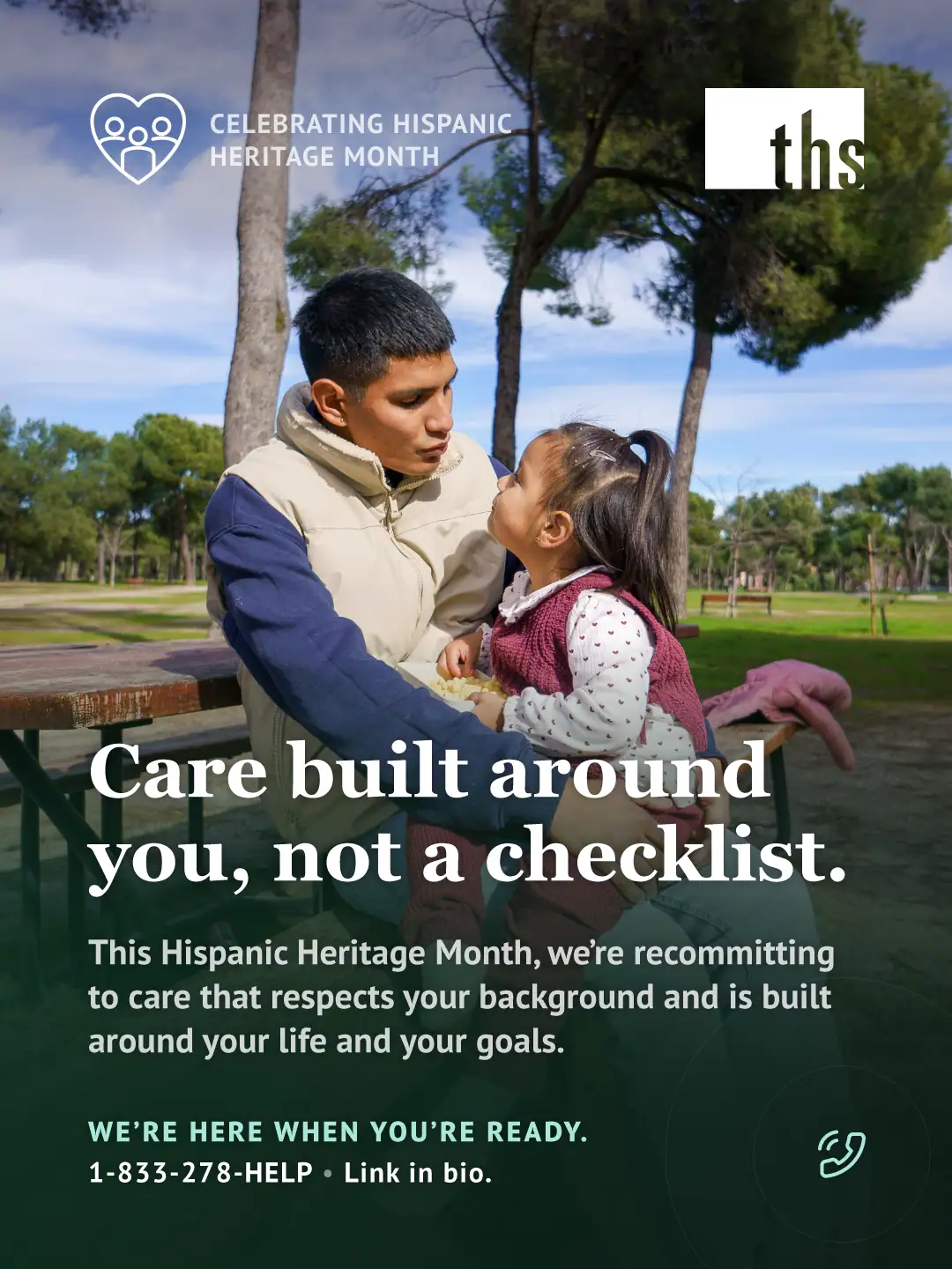 Photo of a father and young daughter sitting close together outdoors in a park, seated at a wooden picnic table with green lawn and trees behind them; he looks down at her with warm attention as they talk. A dark green gradient overlay covers the lower two-thirds of the image. Top left: a heart-with-people icon and the text "CELEBRATING HISPANIC HERITAGE MONTH." Top right: the THS logo. Bold white headline: "Care built around you, not a checklist." Below it: "This Hispanic Heritage Month, we're recommitting to care that respects your background and is built around your life and your goals." Bottom left, in mint: "WE'RE HERE WHEN YOU'RE READY." followed by "1-833-278-4357 • Link in bio." A small phone icon appears bottom right.