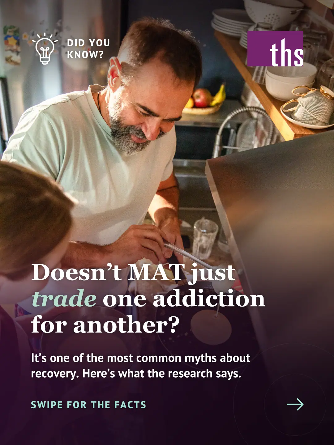 Photo of a smiling middle-aged man with a gray beard pouring pancake batter into a pan in a warm, sunlit home kitchen while a child holds the mixing bowl beside him. A dark purple gradient covers the lower half. Top left: a lightbulb icon and the text "DID YOU KNOW?" Top right: the THS logo. Bold white serif headline: "Doesn't MAT just trade one addiction for another?" with "trade" in mint italic. Below it: "It's one of the most common myths about recovery. Here's what the research says." Bottom left, in mint: "SWIPE FOR THE FACTS" with a right arrow.